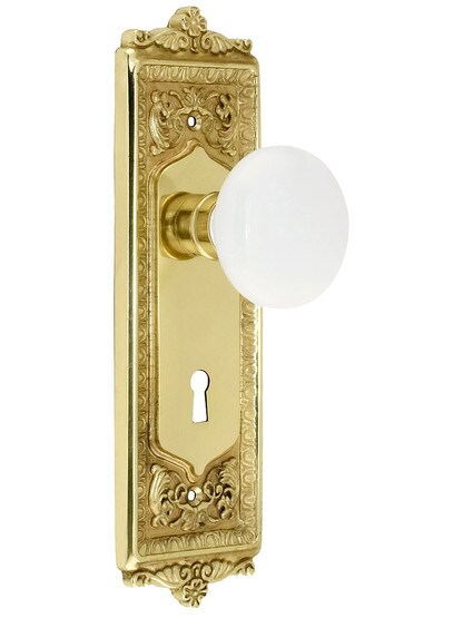 Egg and Dart Style Mortise Lock Set with White Porcelain Door Knobs in Polished Brass.